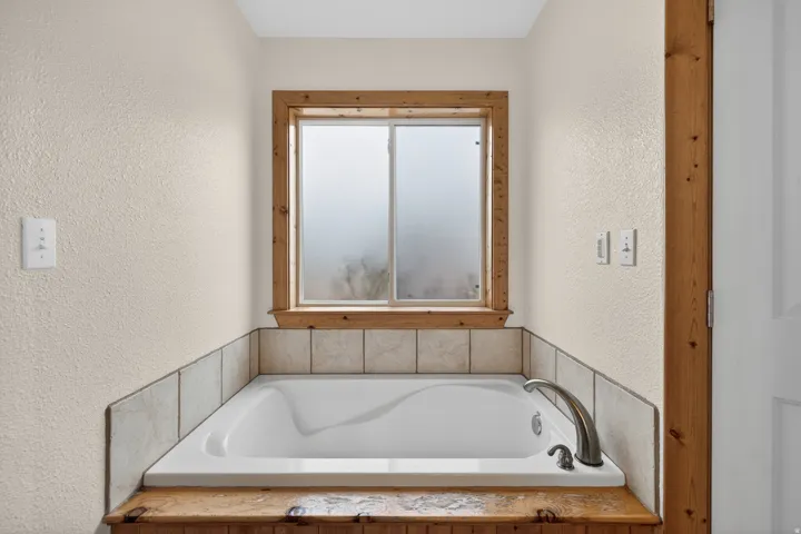 Bathroom with a textured wall and a bath
