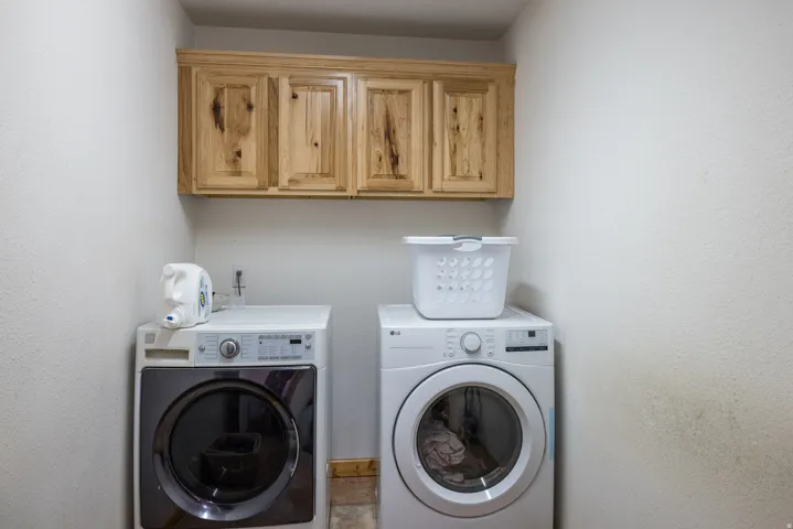 Laundry room featuring cabinet space and washer and clothes dryer