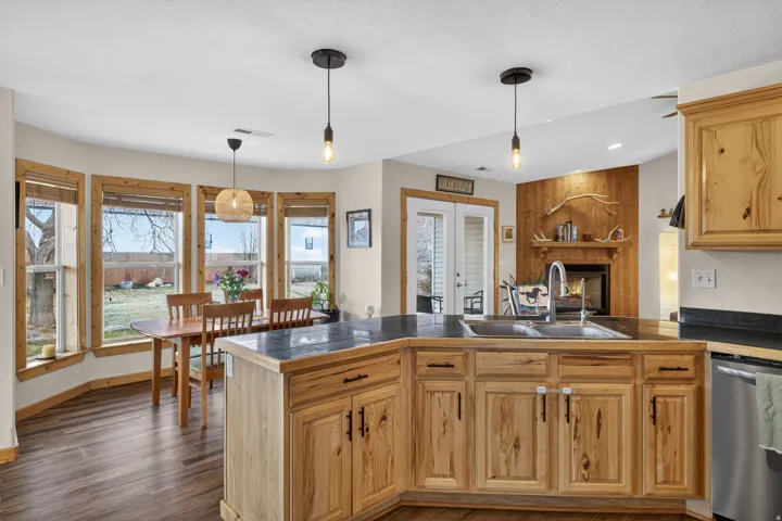 Kitchen with tile counters, french doors, stainless steel dishwasher, and pendant lighting