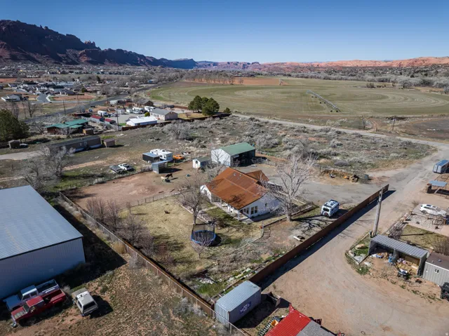 Aerial view of property and surrounding area with mountains and nearby suburban area
