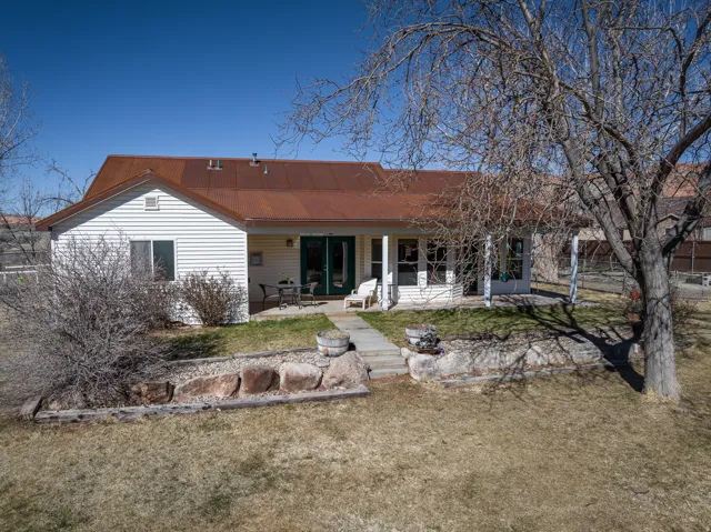 Rear view of property with a metal roof, a patio, french doors, and a yard