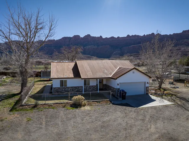 View of front of home featuring concrete driveway, a porch, an attached garage, a mountain view, and stone siding
