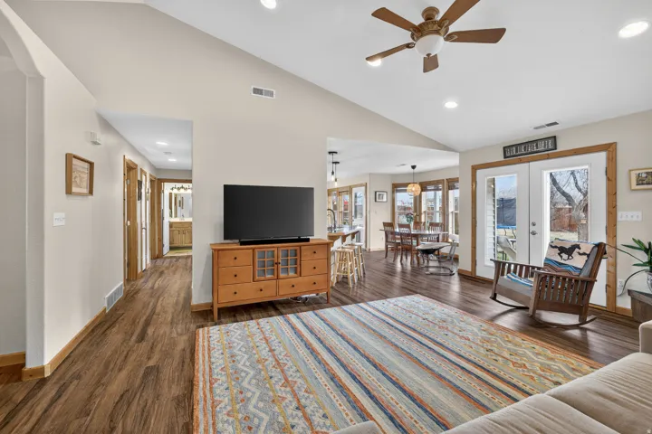 Living area featuring french doors, lofted ceiling, dark wood-style floors, a ceiling fan, and recessed lighting