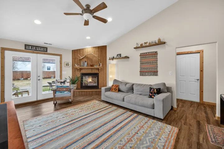Living room with french doors, ceiling fan, dark wood-type flooring, recessed lighting, and a fireplace