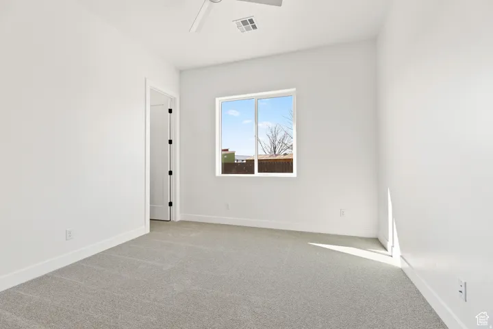 Unfurnished room featuring light colored carpet and ceiling fan