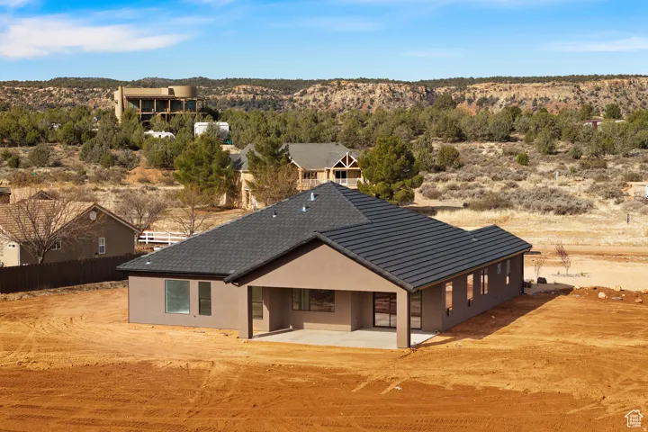 Back of house with stucco siding, a patio area, a mountain view, and view of desert