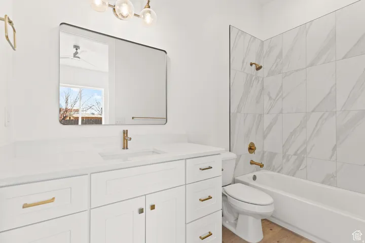 Bathroom featuring vanity, tub / shower combination, and light wood-type flooring