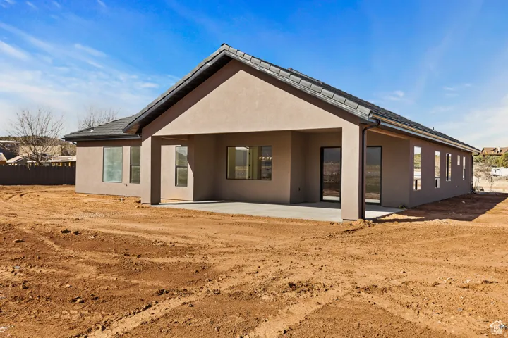 Rear view of property featuring a patio and stucco siding