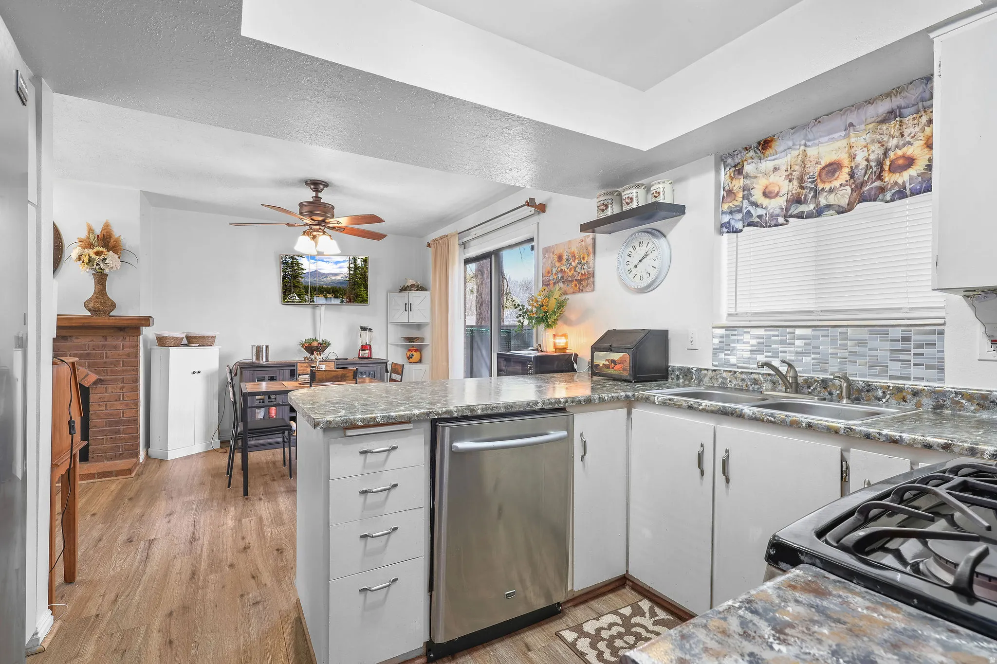 Kitchen featuring a peninsula, black gas range, stainless steel dishwasher