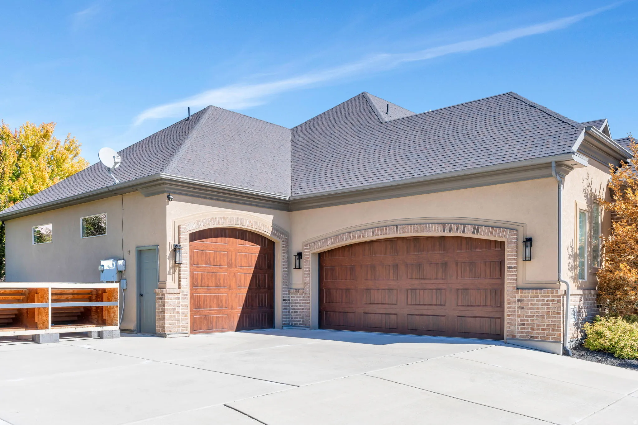 View of home's exterior with an attached garage, stucco siding, brick siding, and concrete driveway