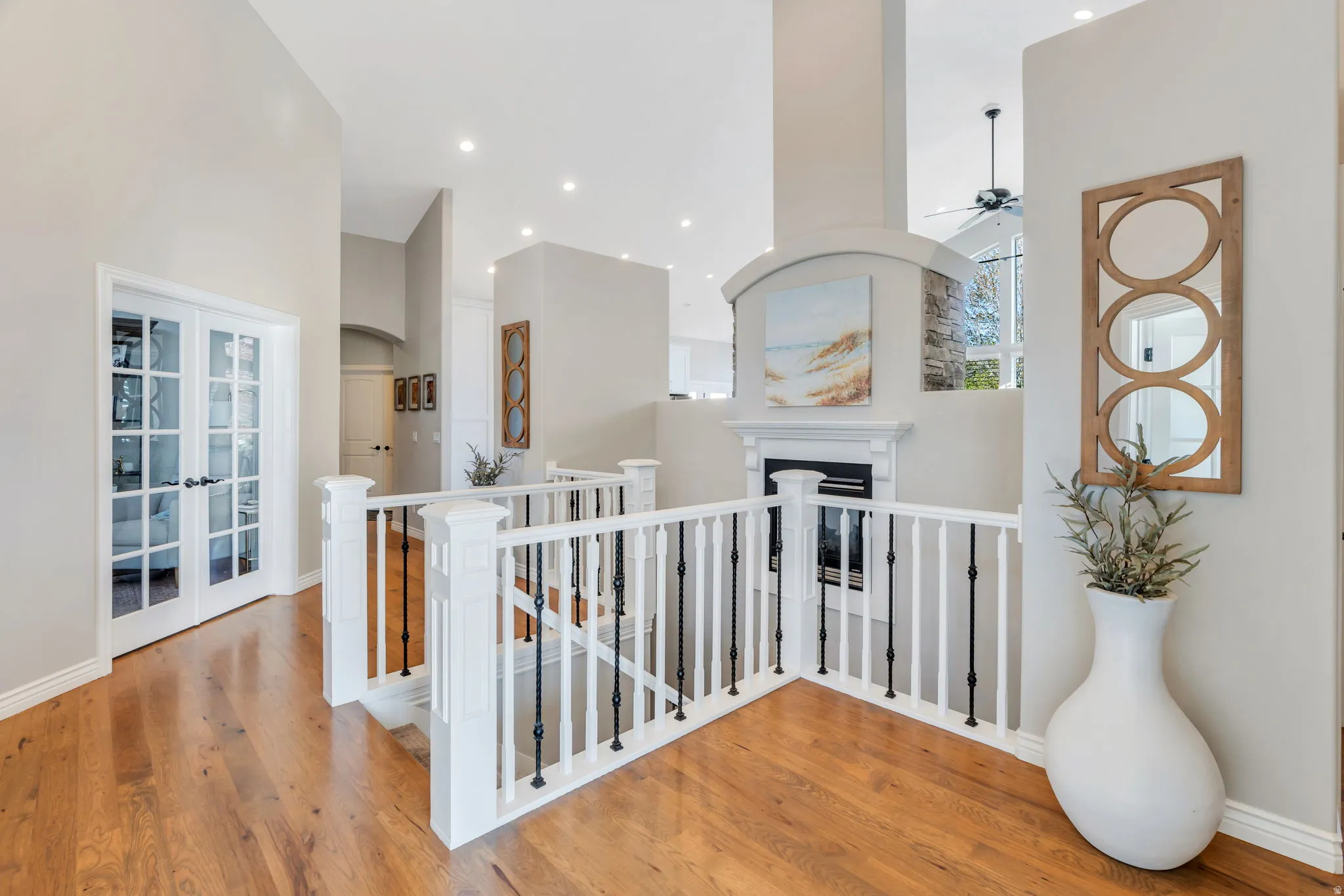 Wood-finish flooring throughout, featuring a white spindle and iron baluster railing system