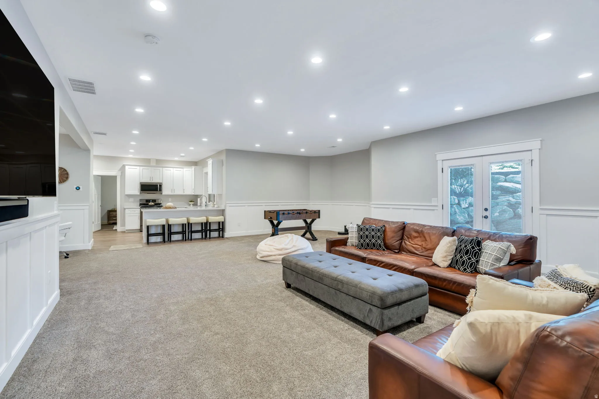 Family  room with wainscoting, outside entrance, carpet, and recessed lighting