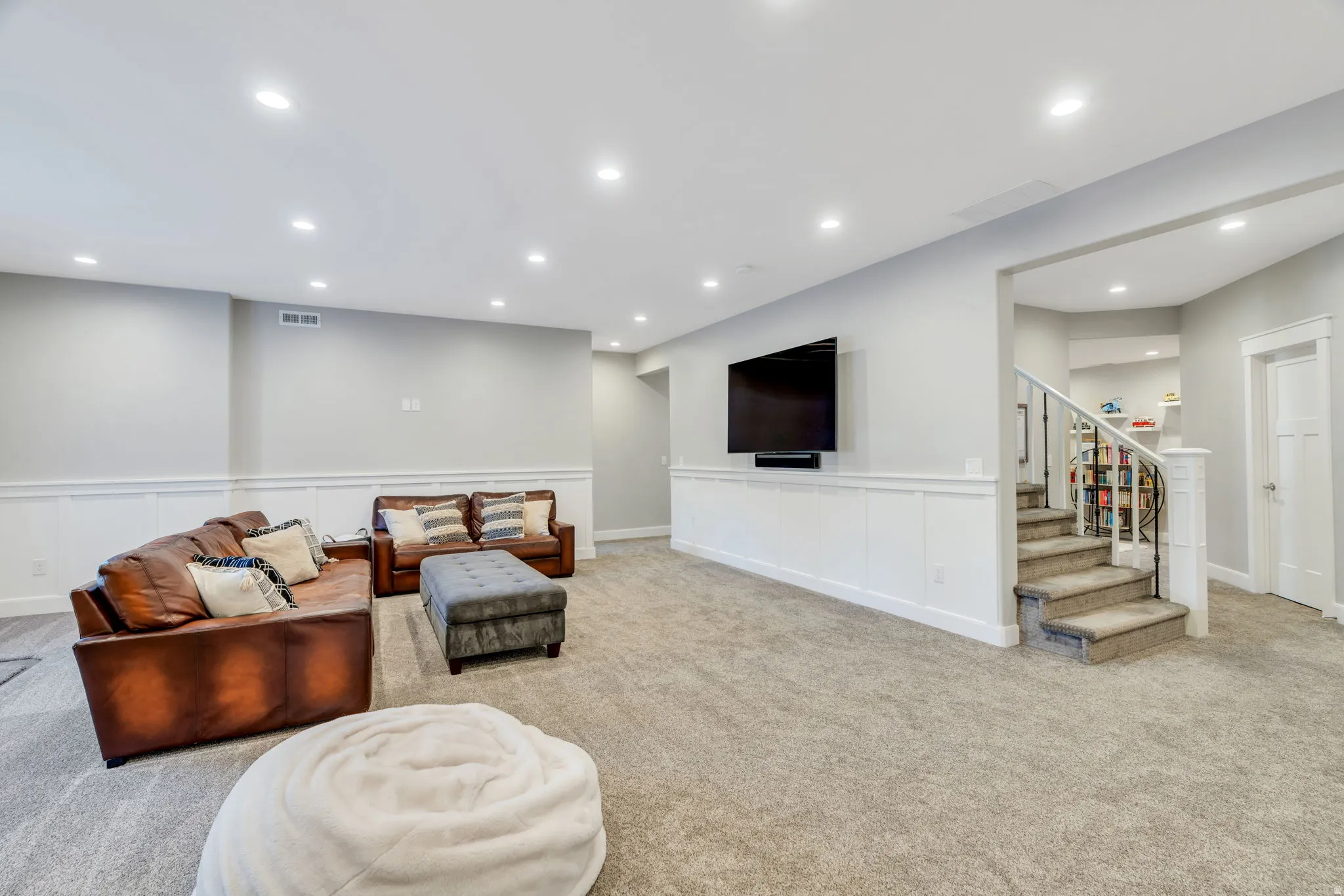 Downstairs family room with recessed lighting, carpet and a wainscoting