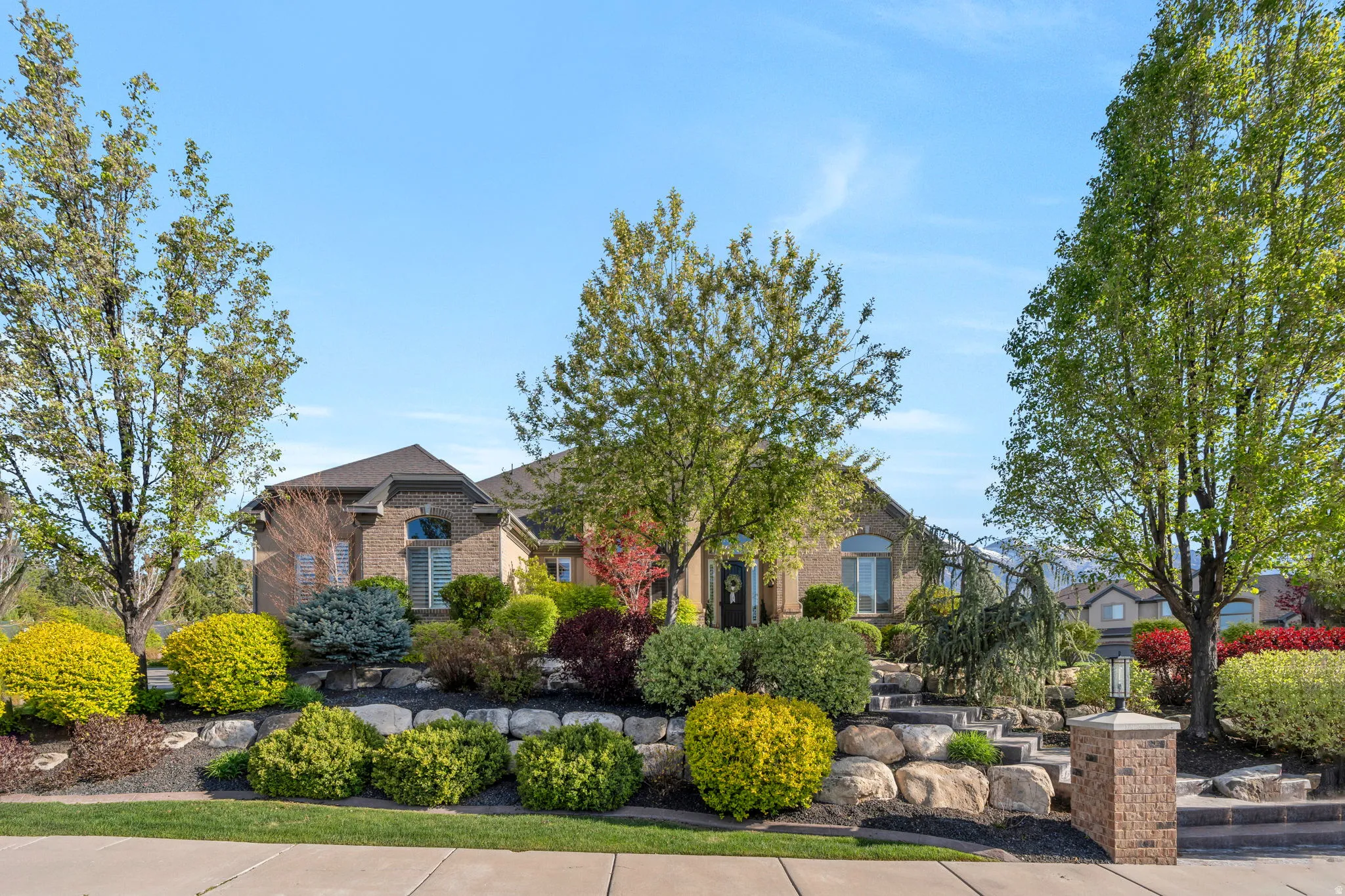 Brick facade residence with a dark shingle roof and arched windows