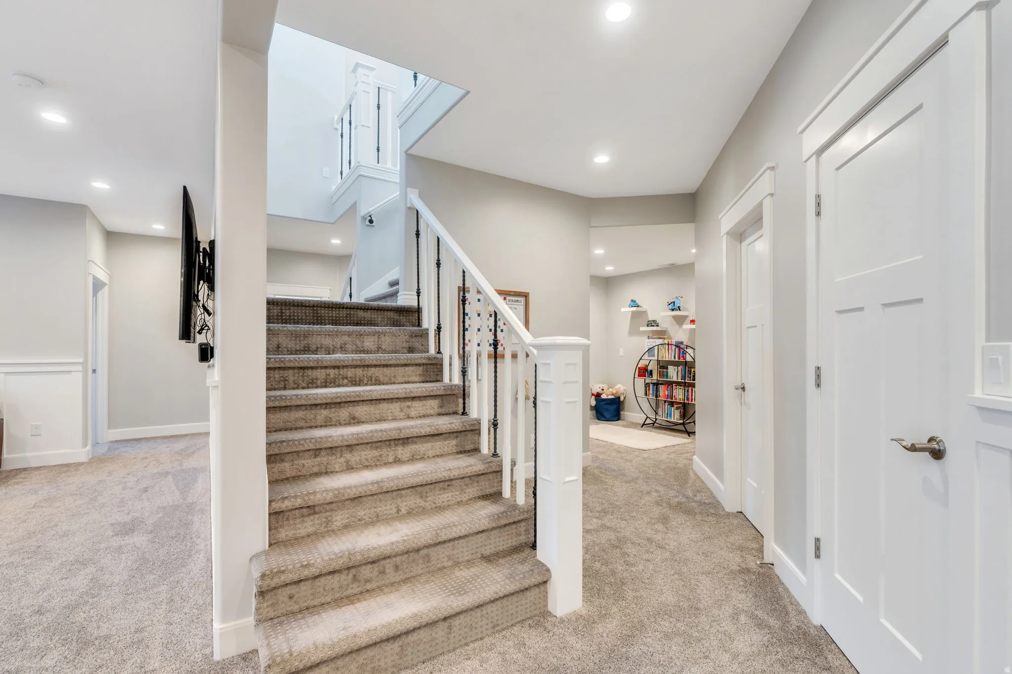 Stairs with carpet floors and recessed lighting