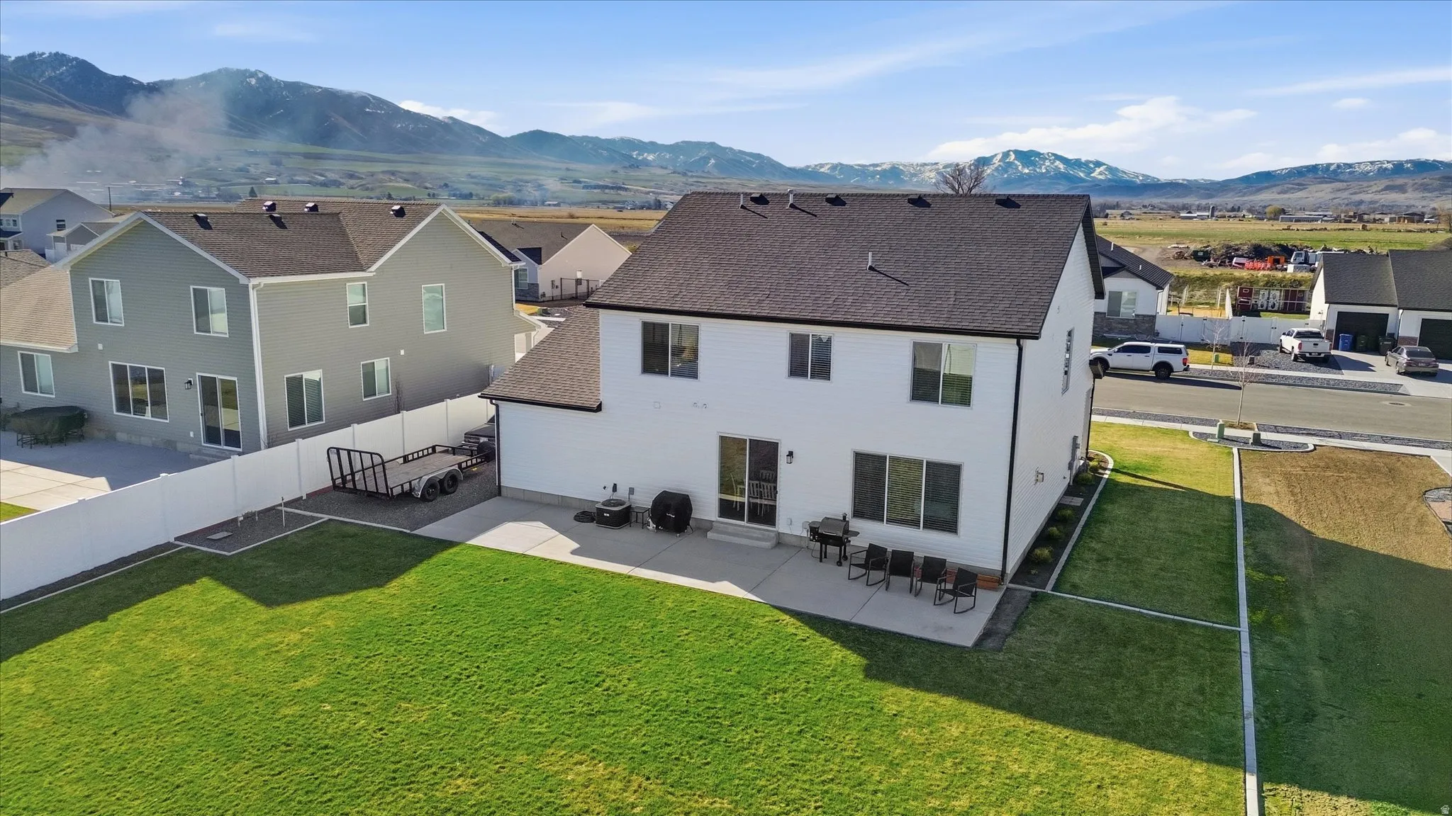 Back of house with a patio area, a mountain view, a residential view, and a fenced backyard