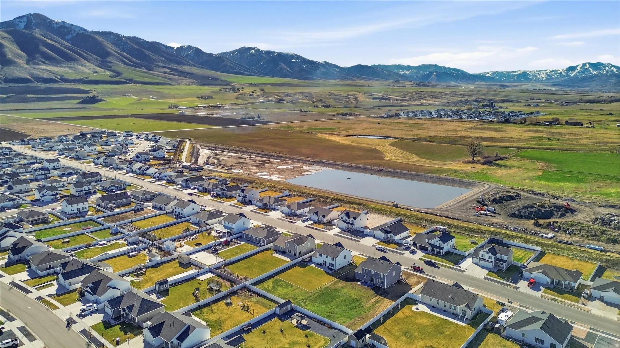 Aerial view of property and surrounding area featuring a water and mountain view and nearby suburban area