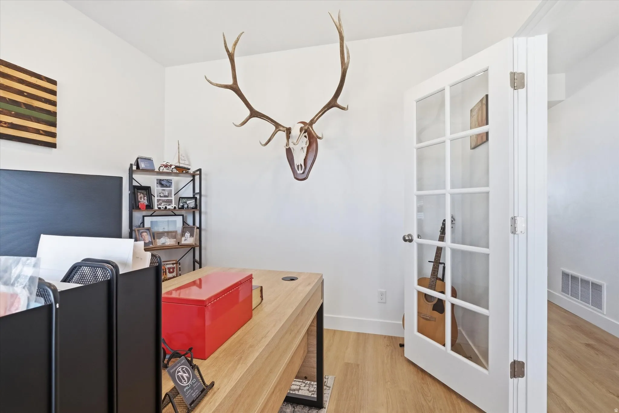 Home office with light wood finished floors and baseboards