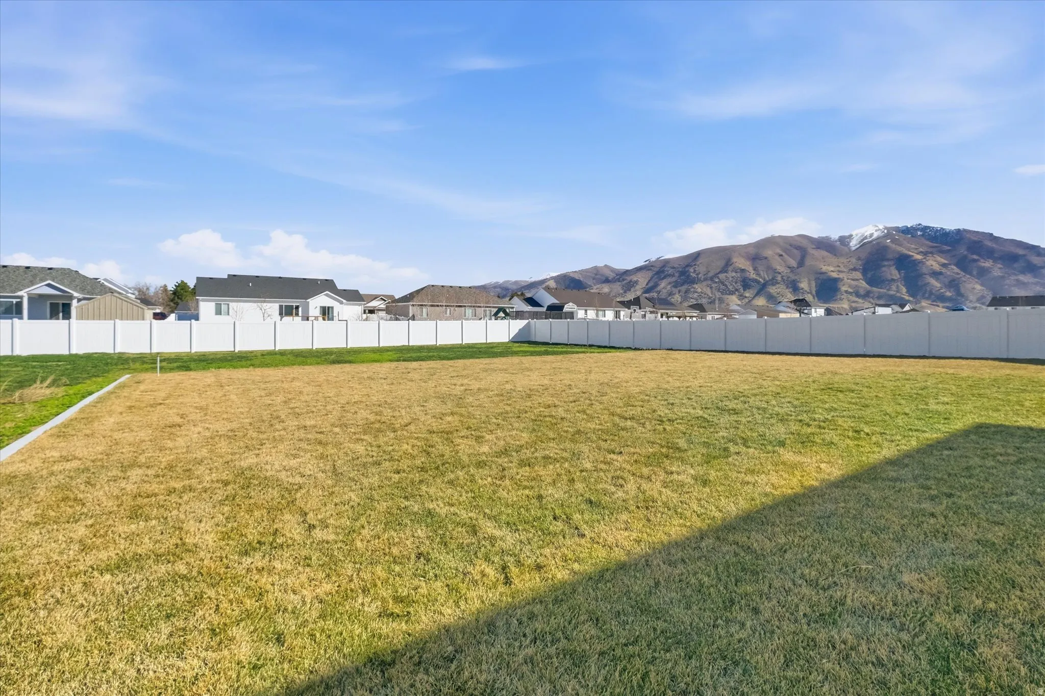 Fenced backyard featuring a mountain view