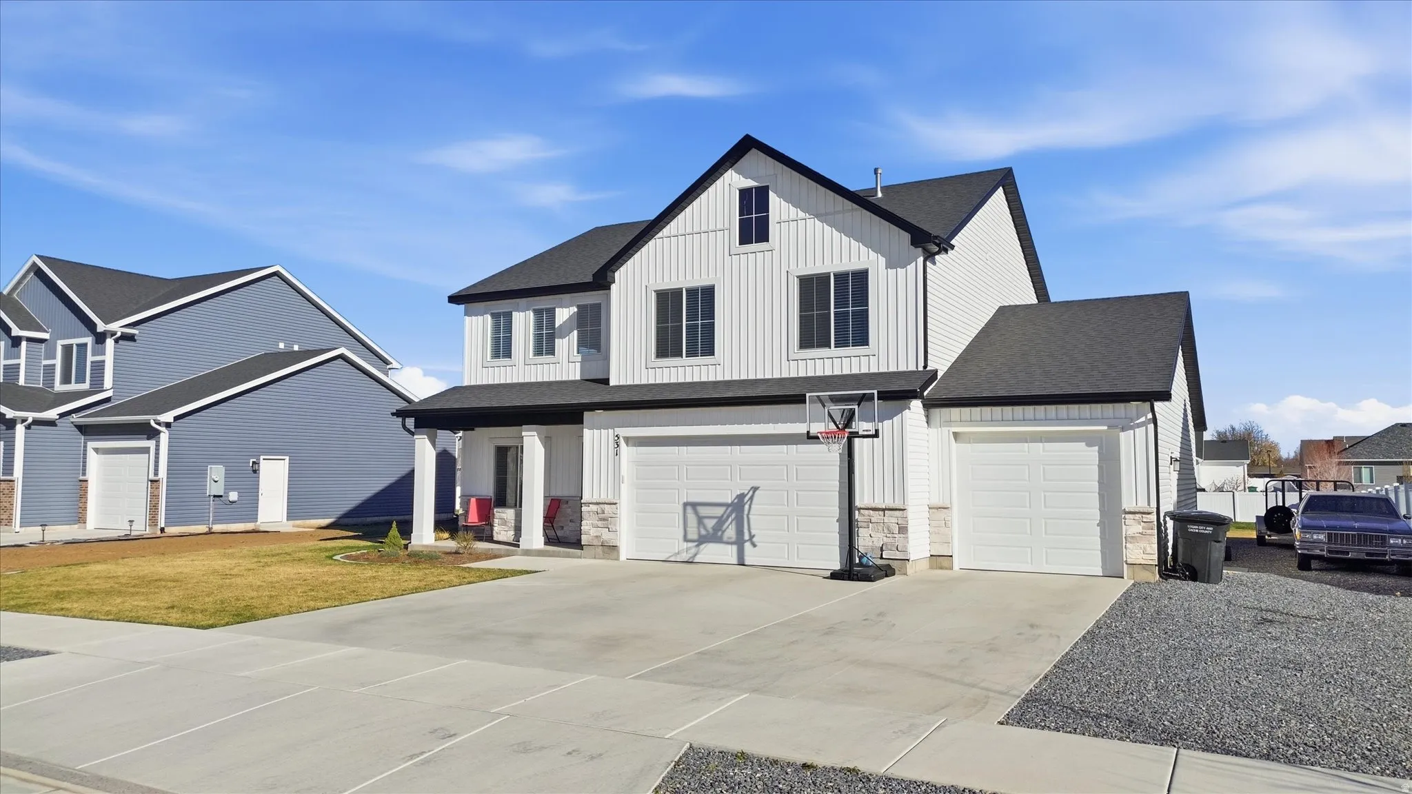 View of front facade featuring board and batten siding, concrete driveway, and an attached garage