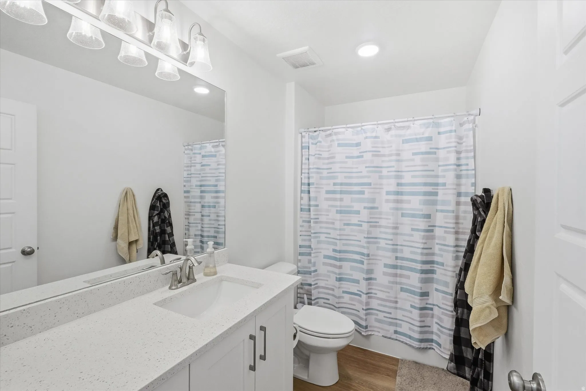 Upstairs Full Bathroom with vanity, dark wood-style floors, and shower / bath combination with curtain