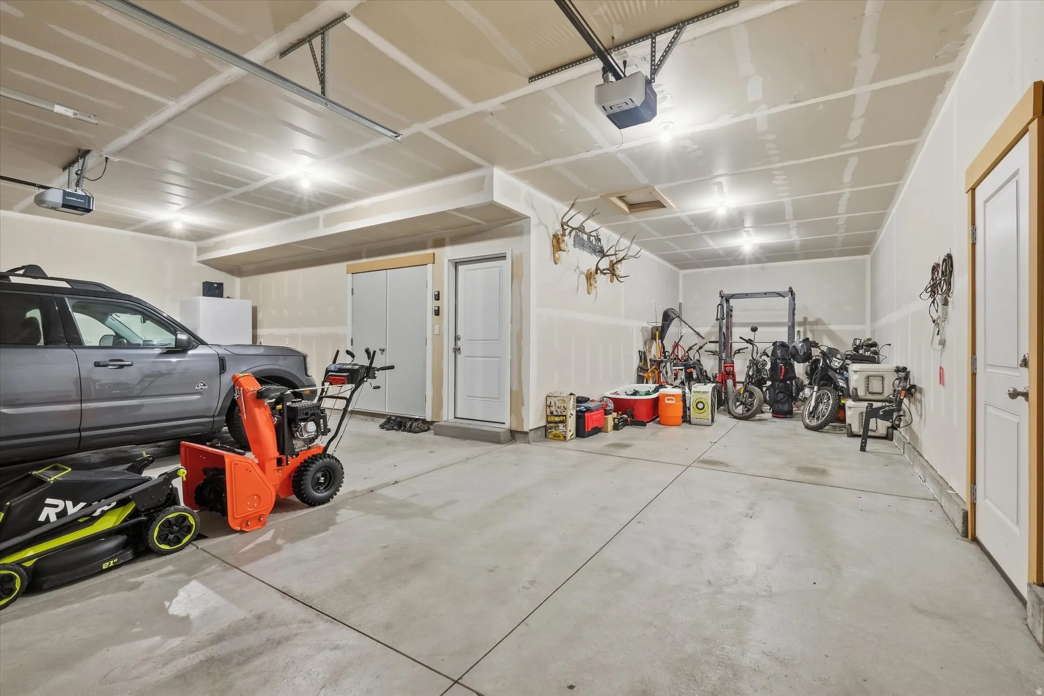 Garage featuring a garage door opener with an extra deep third car garage