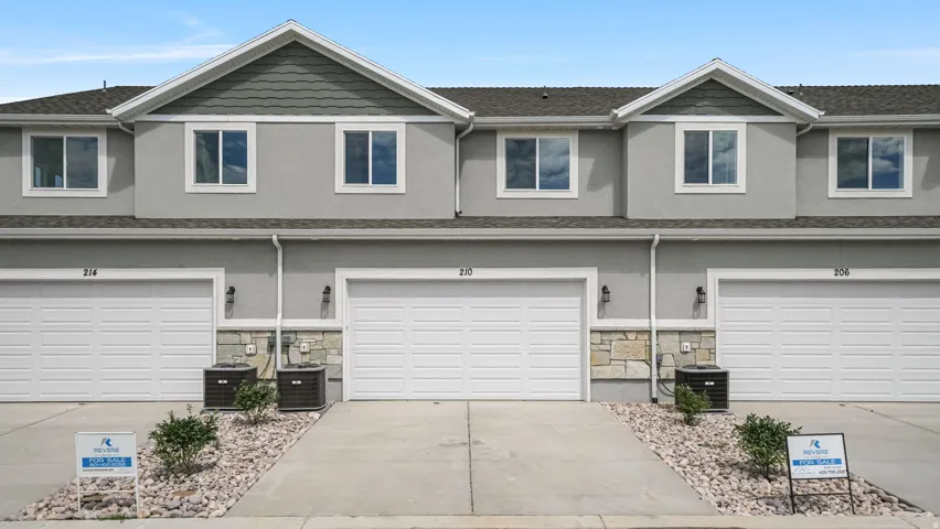 Multi-unit property featuring a stucco and stone exterior with peaked rooflines