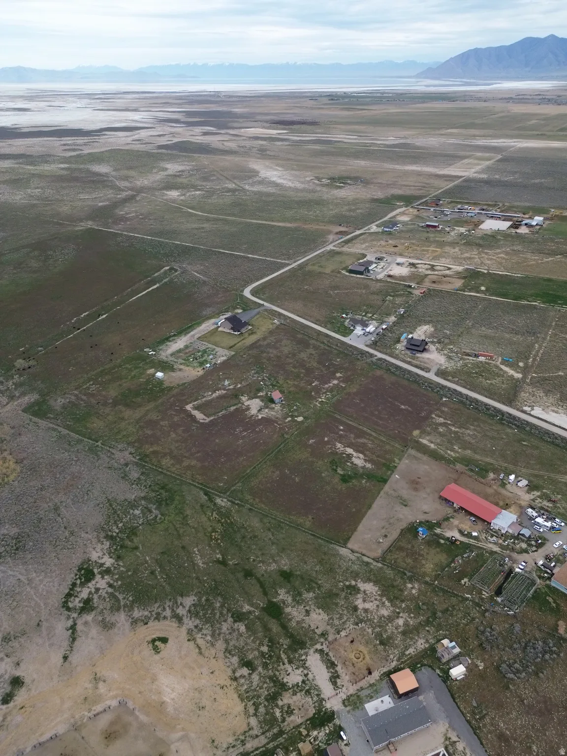 Aerial overview of property's location featuring rural landscape, a mountain backdrop, and rows of crops