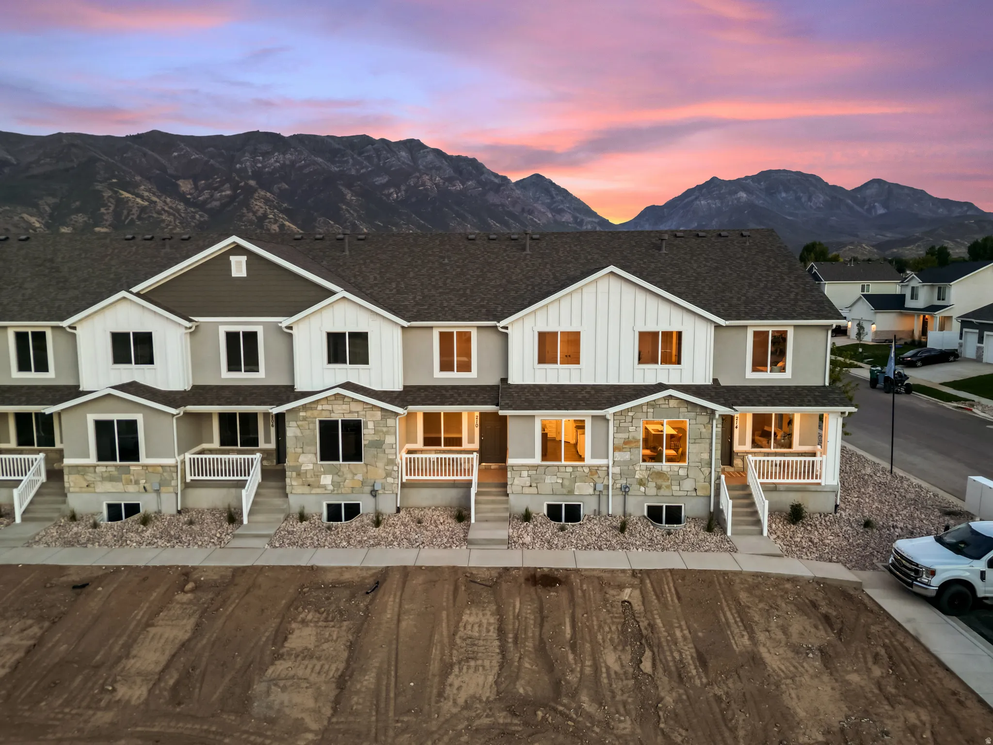 Modern townhome exteriors featuring varied siding, stone accents, and white trim