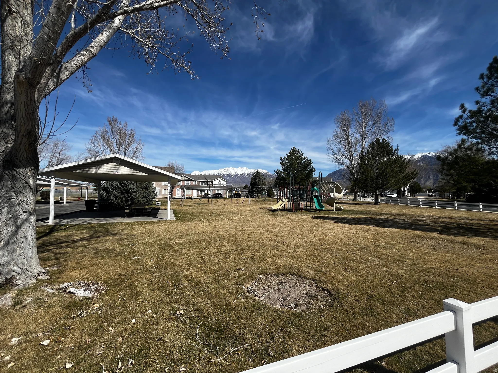 View of yard featuring a playground, a mountain view, and a patio