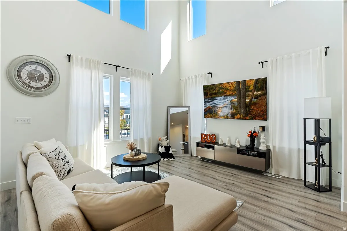 Living room with light wood-style floors and a high ceiling