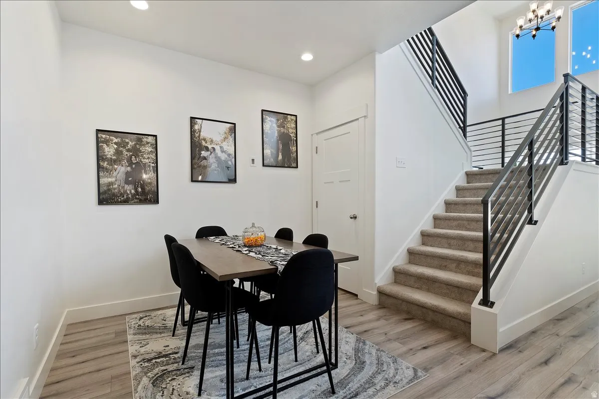 Dining area with light wood-style floors and hanging lights