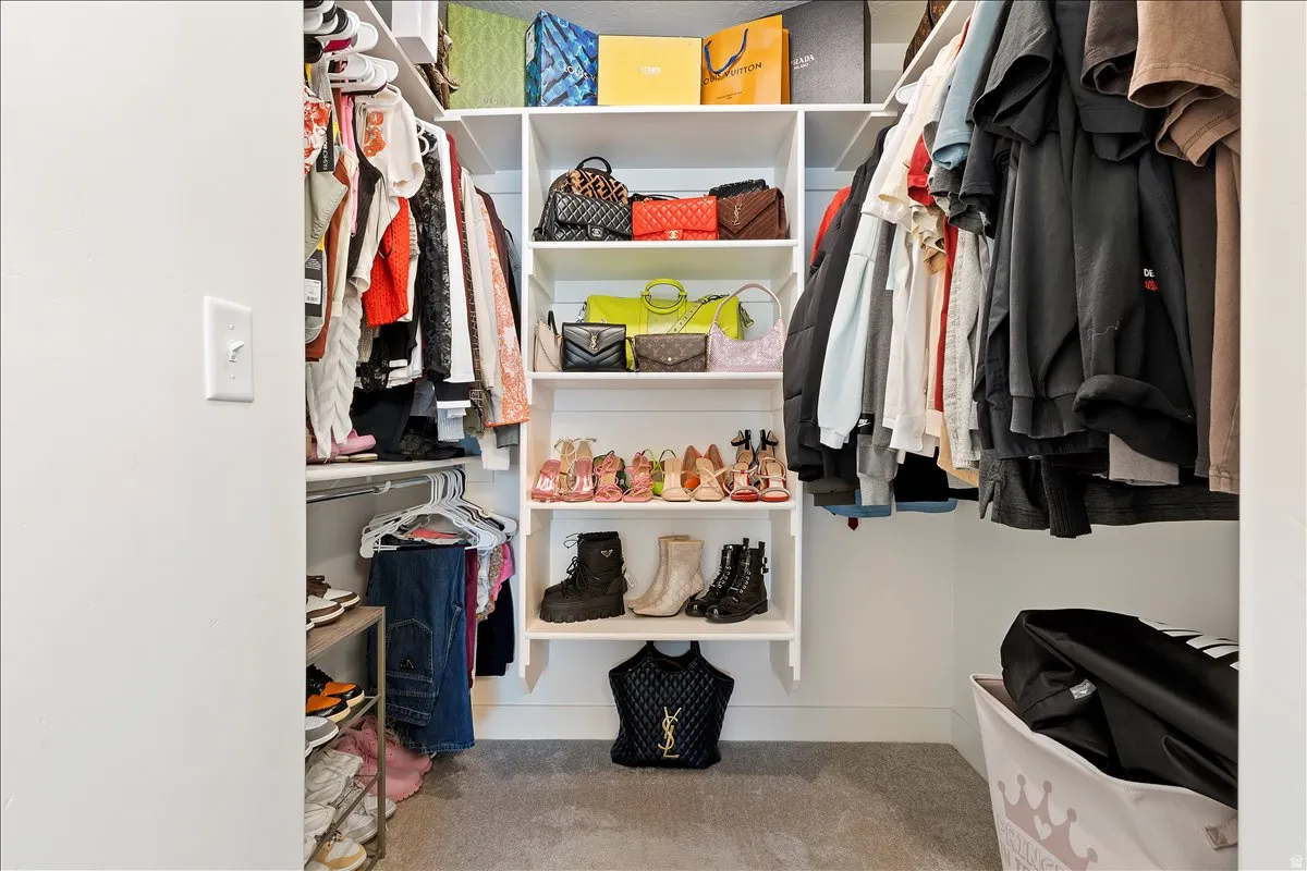Walk in closet featuring light colored carpet
