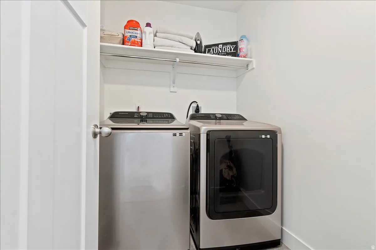 Laundry room with independent washer and dryer and baseboards