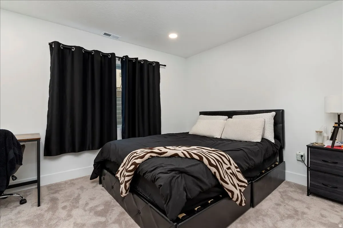 Carpeted bedroom with baseboards and recessed lighting