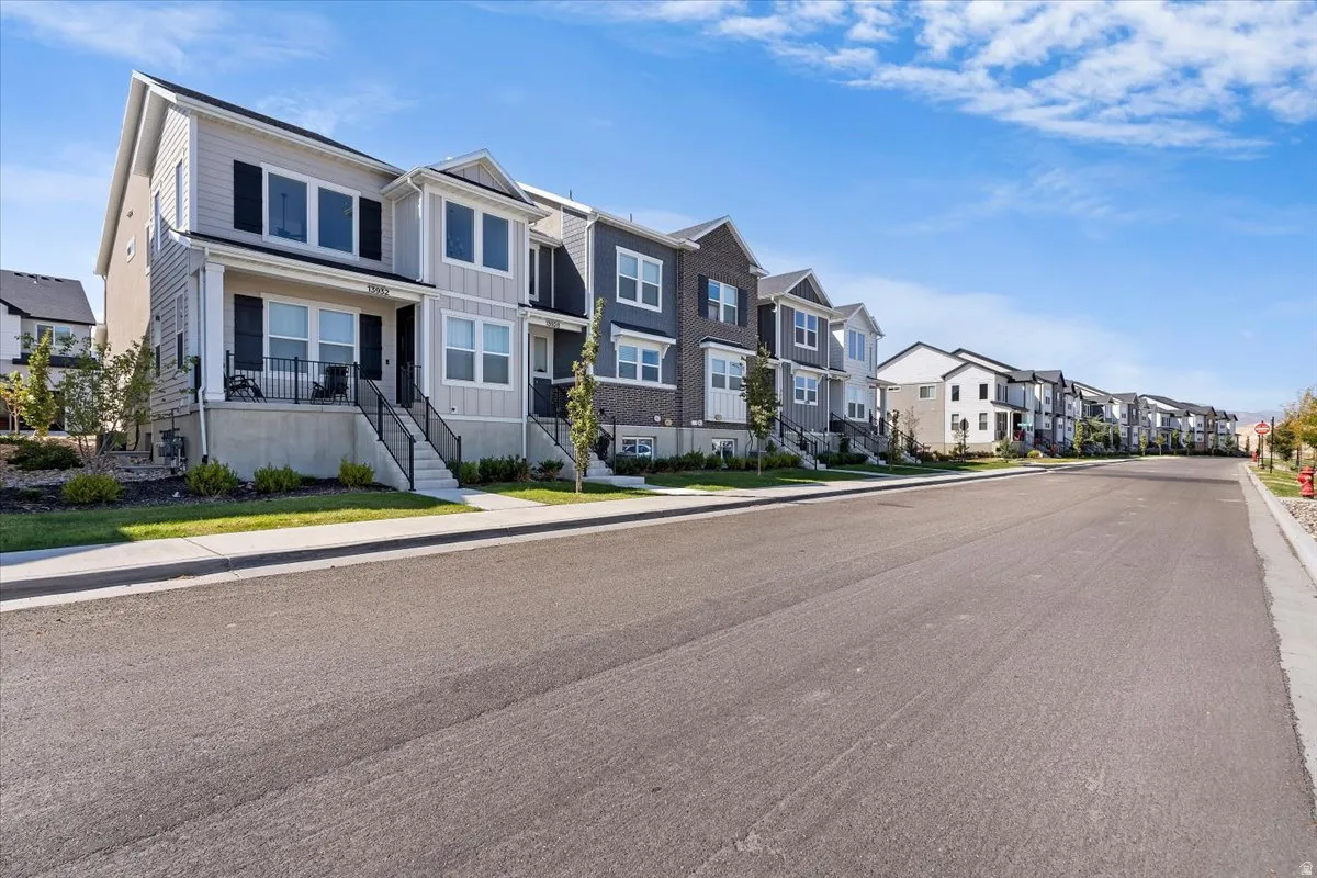 View of asphalt road with sidewalks, curbs, and a residential view
