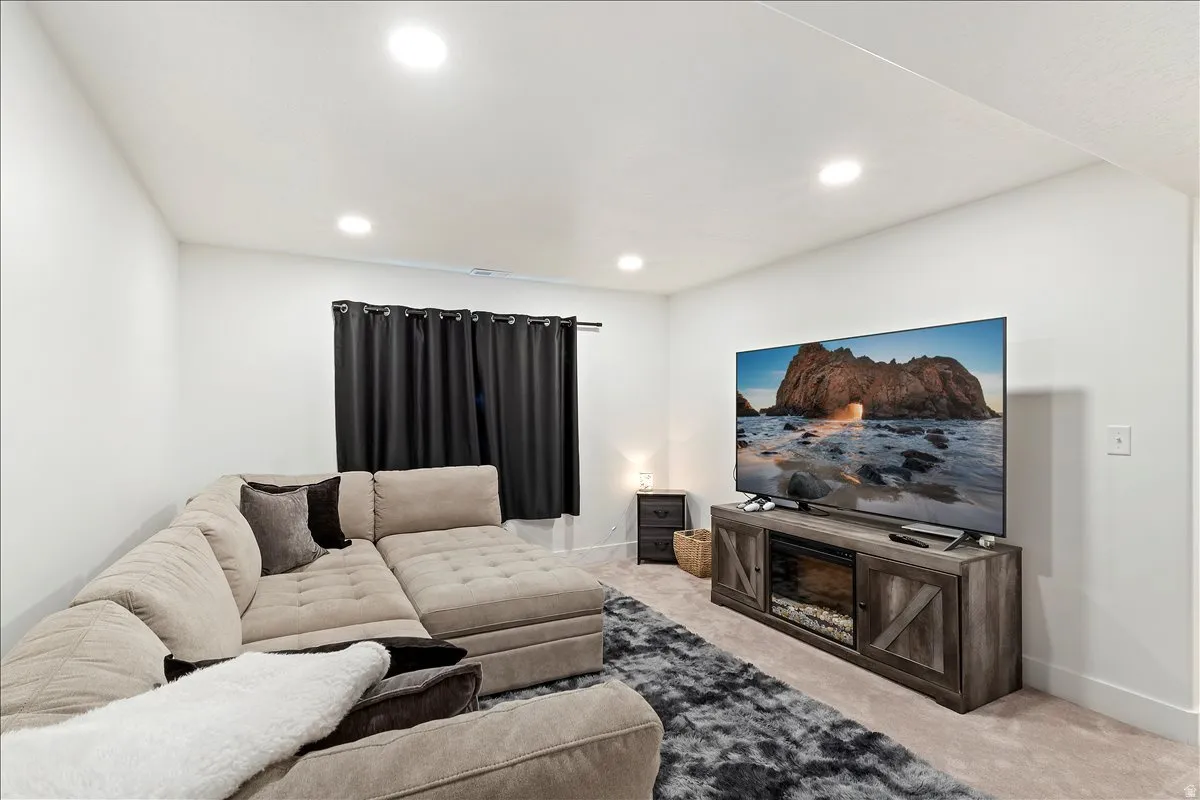 Carpeted living room featuring baseboards and recessed lighting