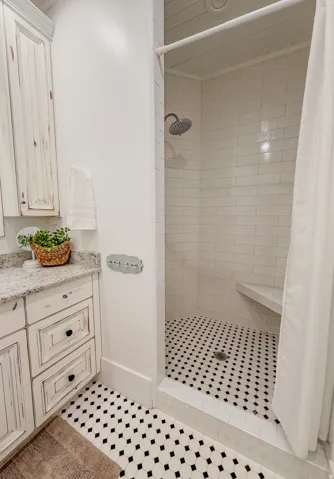 Bathroom featuring vanity, a shower stall, and light tile patterned flooring