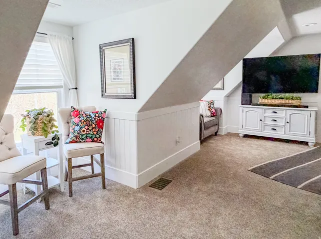 Sitting room with light carpet and wainscoting