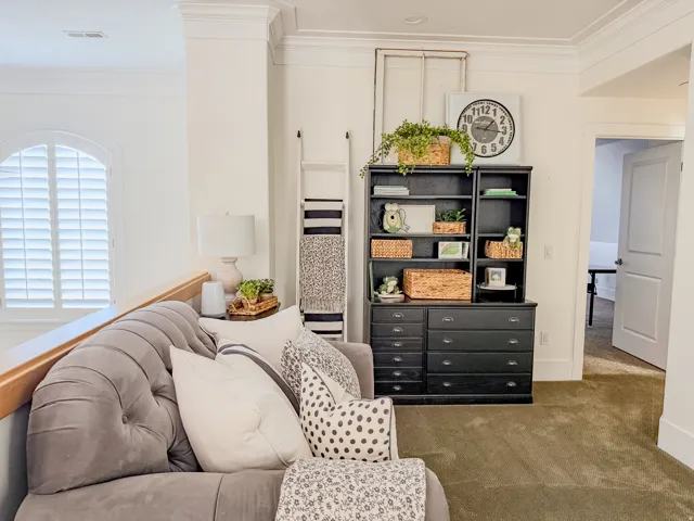 Living area featuring crown molding and carpet