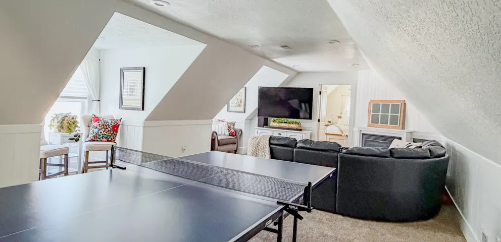 Rec room with carpet floors and a wainscoted wall