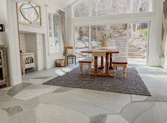 Dining area featuring stone floors, lofted ceiling, and wood walls