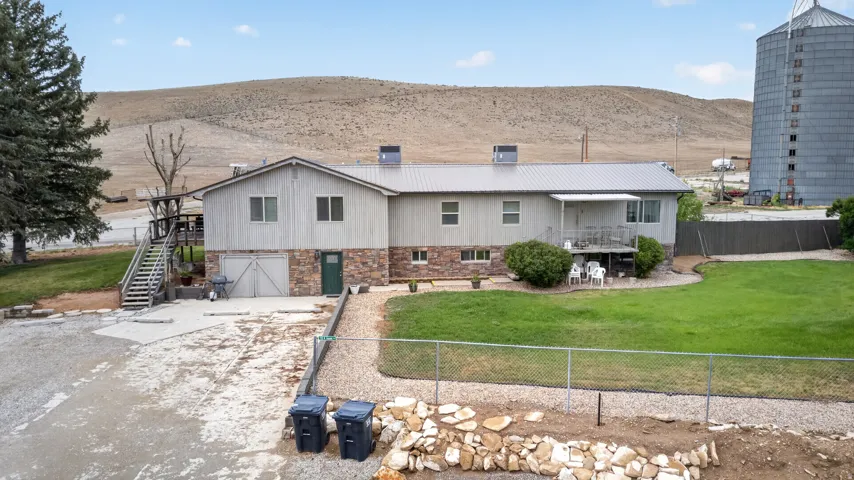 Exterior featuring a metal roof, stone veneer accents, and a covered back porch with a separate deck