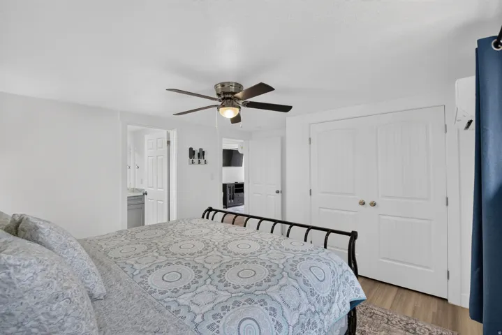 Unit 2A: Recessed lighting, ceiling fan, wood-finish flooring, white paneled doors, and an air conditioning unit