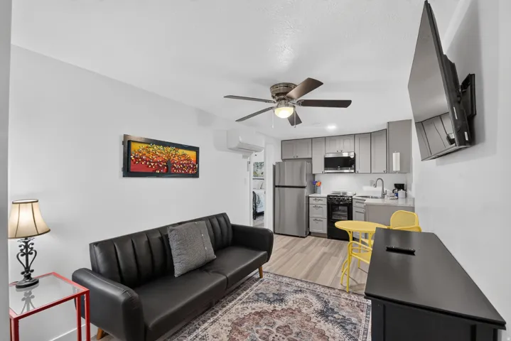 Unit 2A: Compact kitchen featuring stainless steel appliances, upper and lower cabinetry, and a single basin sink