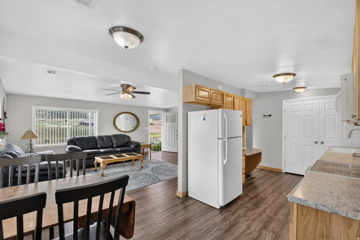 Unit 3: Open-concept living space featuring wood-finish flooring, a ceiling fan, light wood cabinetry, and a double-door closet