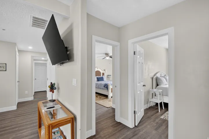 Unit 1: Wood-finish flooring throughout, light neutral wall paint, white trim, and recessed lighting