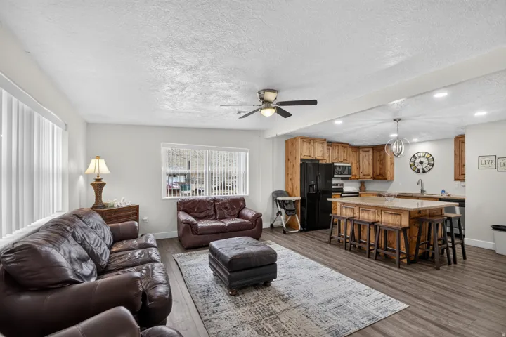Unit 1: Open-concept living area featuring wood-finish flooring, recessed lighting, and a ceiling fan