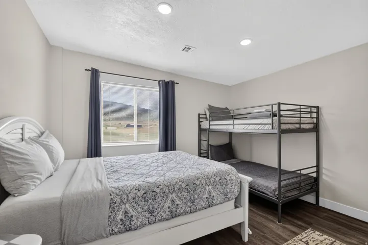 Unit 1: Recessed ceiling lighting, wood-finish flooring, and a large window with horizontal blinds