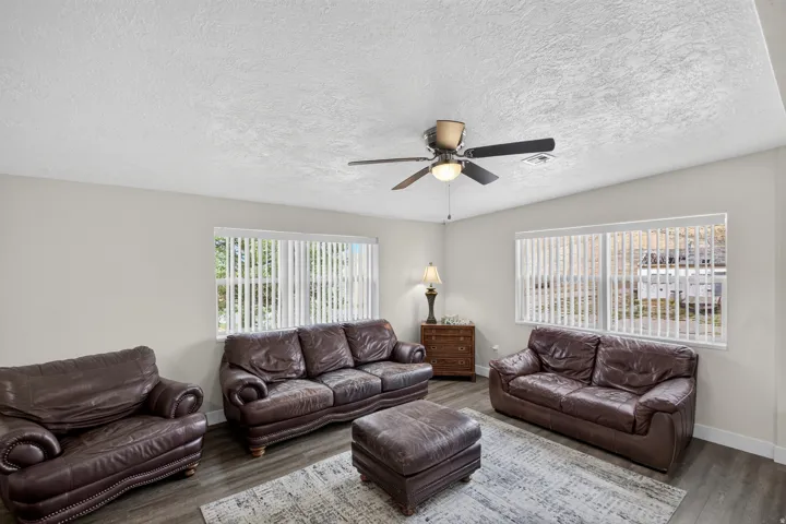 Unit 1: Spacious living room anchored by rich leather seating arrangements and a wood-finish floor